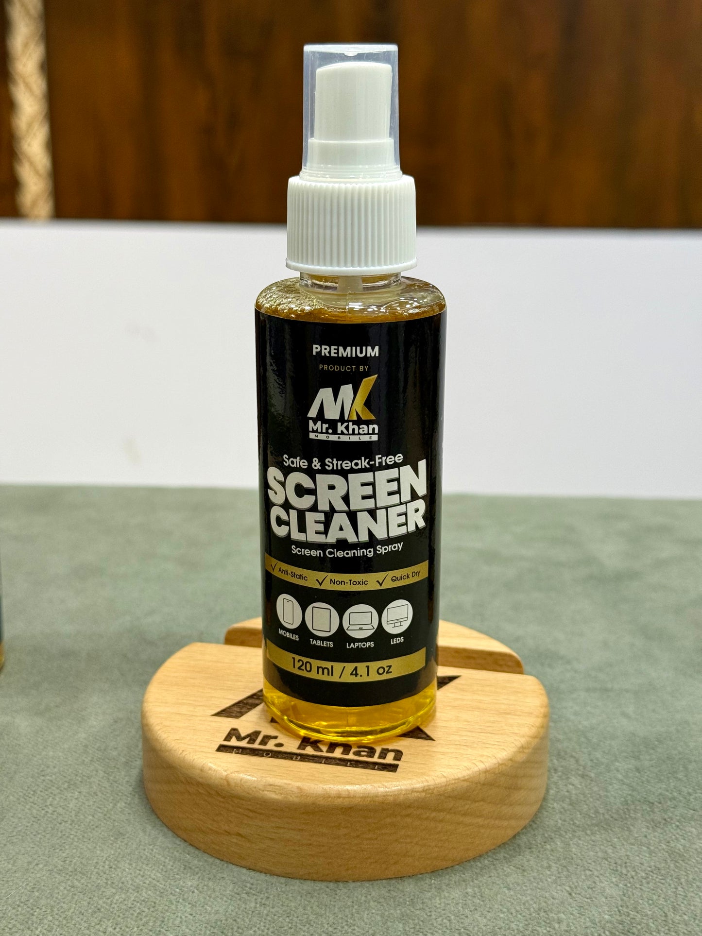 Bottle of screen cleaner on a wooden stand with a blurred background