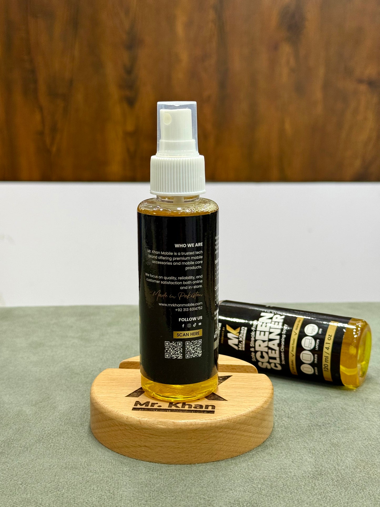Spray bottle and tube of screen cleaner on a wooden stand with a wooden background